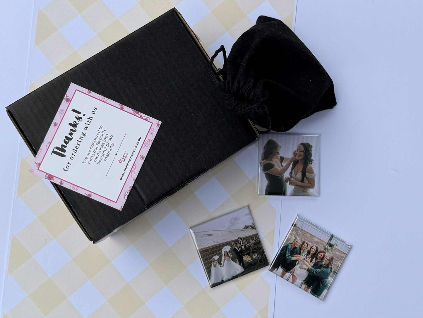3 photo magnets with images of people and a velvet pouch with thank you card and gift box.