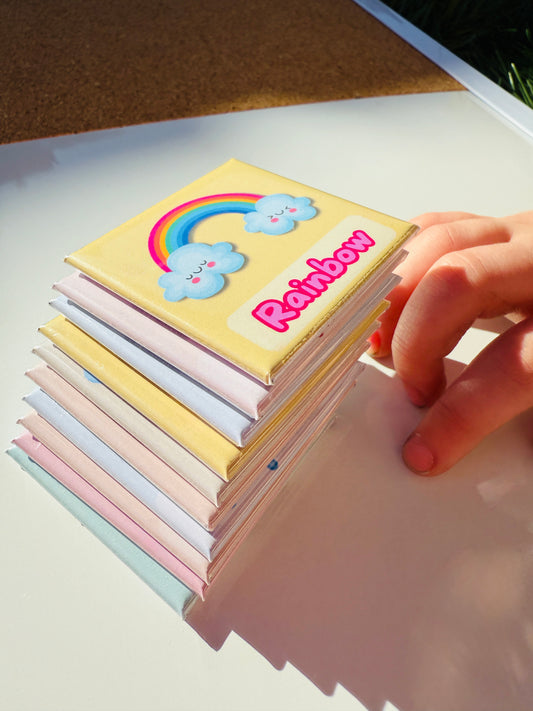 Stack of handmade weather magnets for kids with rainbow design on top