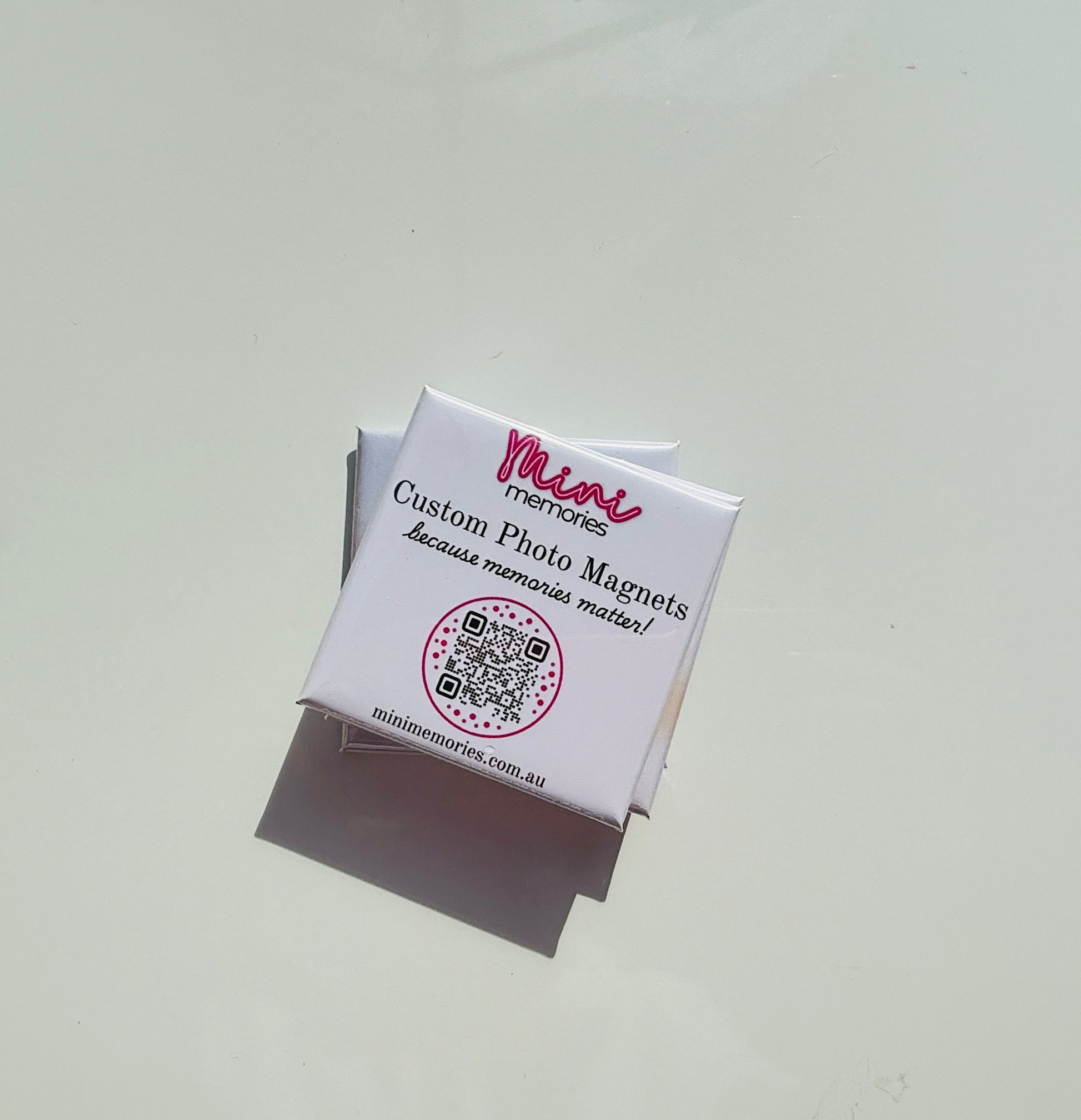 Custom photo magnet packaging with Mini Memories branding, QR code and slogan "because memories matter!"

