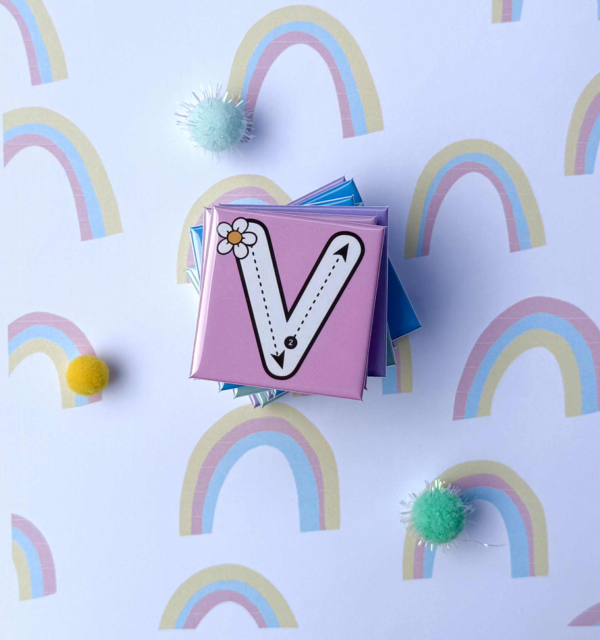 Children's magnet with letter 'V' on a background of rainbows and pom-poms