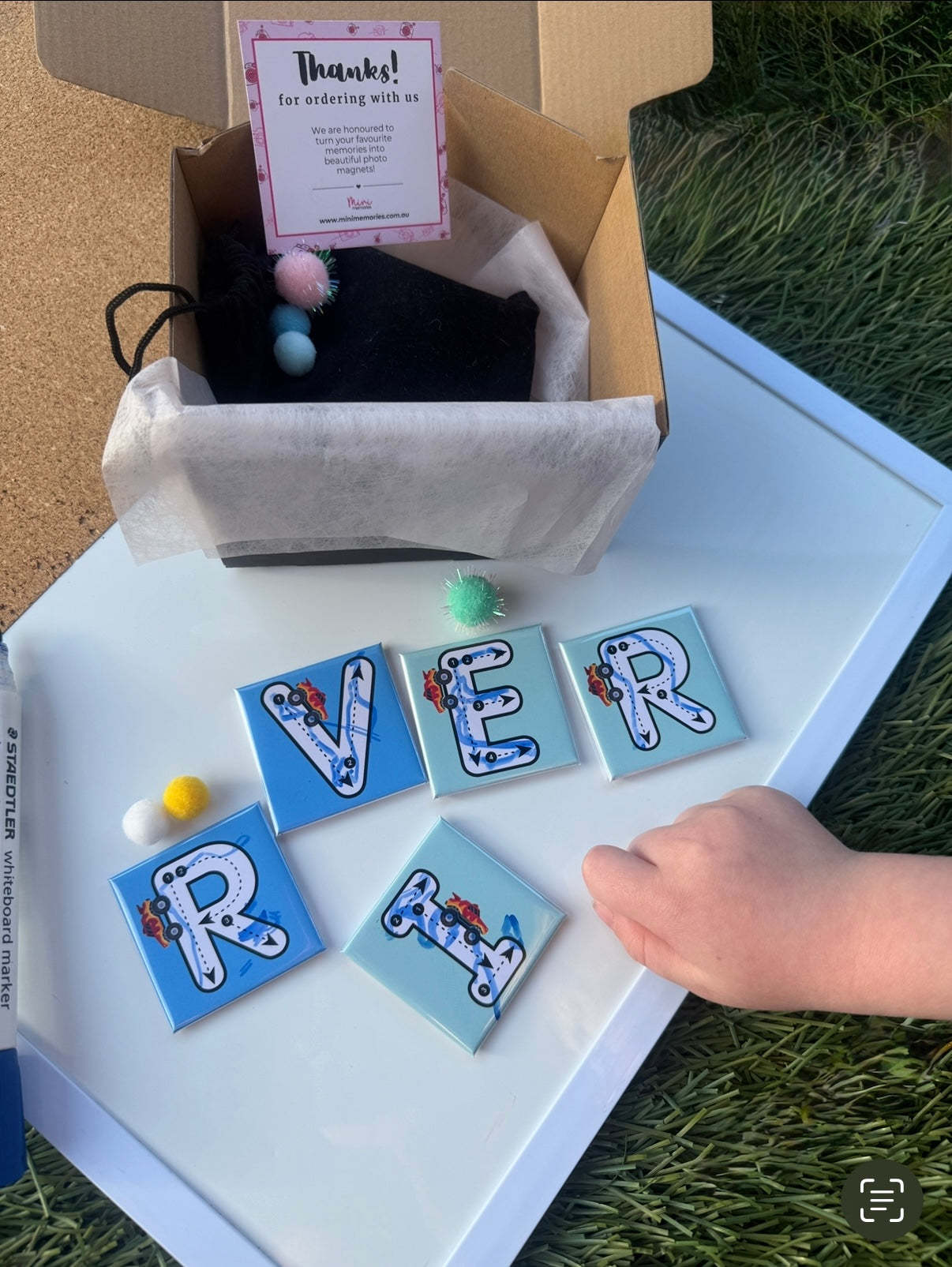 Decorative letter tiles spelling 'RIVER' on a white surface with a box in the background.